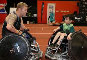 Cameron Leslie introduces a young fan to wheelchair rugby at an Open Day. 