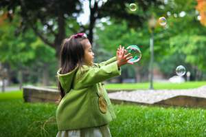 Little girls plays with bubbles Image - Level 3 Covid 