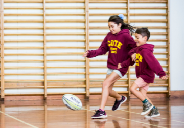 Tū Manawa Media Release Website Tile - children chasing rugby ball indoors 